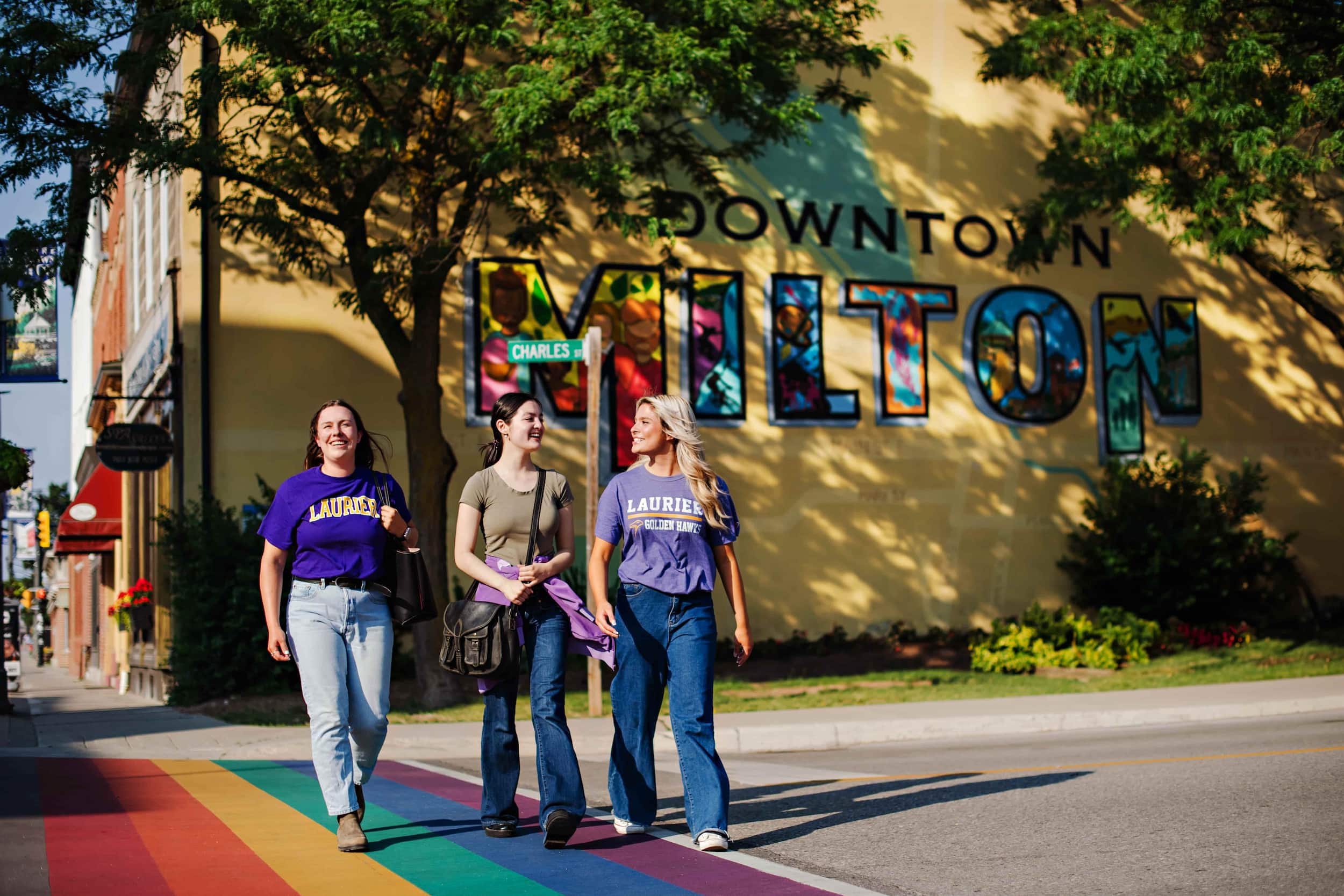 Students crossing a road in downtown Milton on a summer day