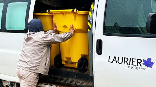 Staff loading yellow move-out bins