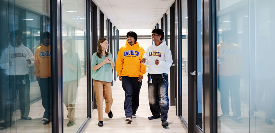students walk Milton campus hallway