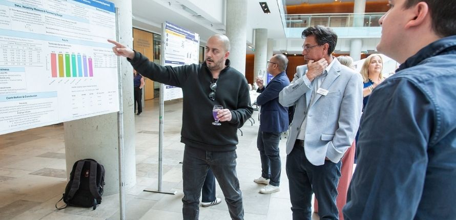 A student delivers their poster presentation