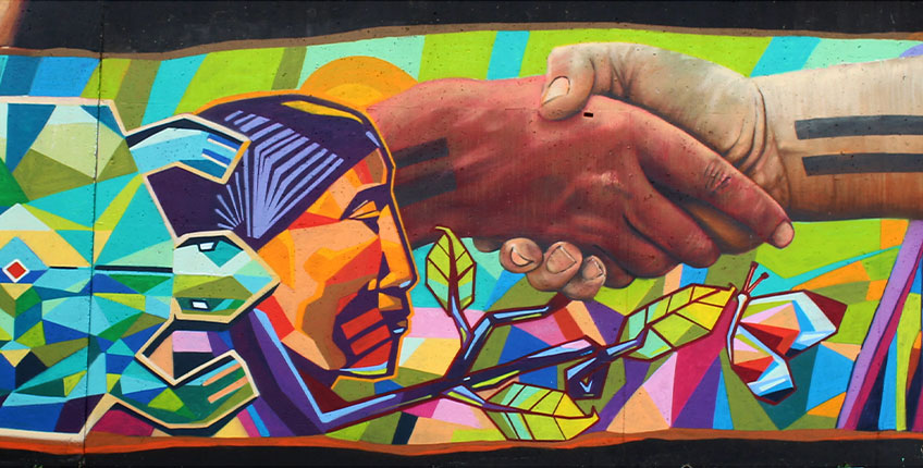 Mural art of a hands shaking, a turtle and person's head