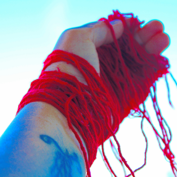 Hand wound with red yarn, raised to the sky