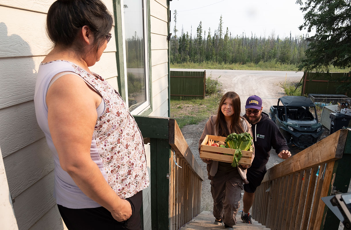 Young girl delivering produce to a neighbour in Kakisa, NWT