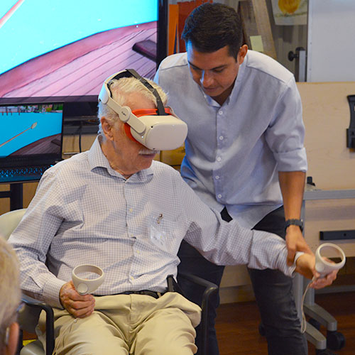 John Munoz testing a virtual reality headset with a senior