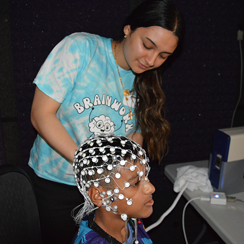 Grad student putting EEG cap on child's head