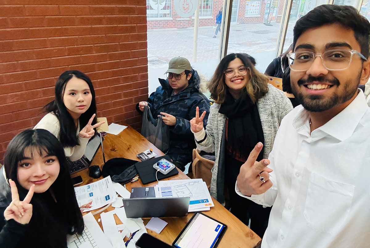 Five students work on a project at the Belmont restaurant on Laurier's Brantford campus