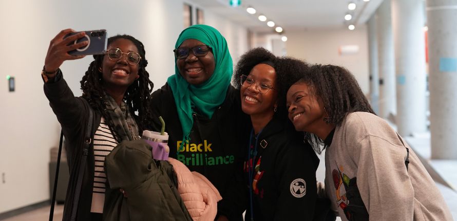 Four women taking a selfie photo.