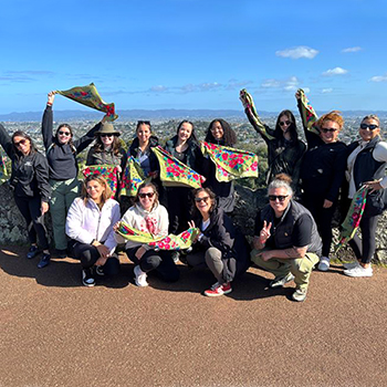 A group of women holding floral scarves. 