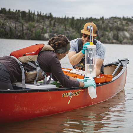 Taking water sample in a canoe