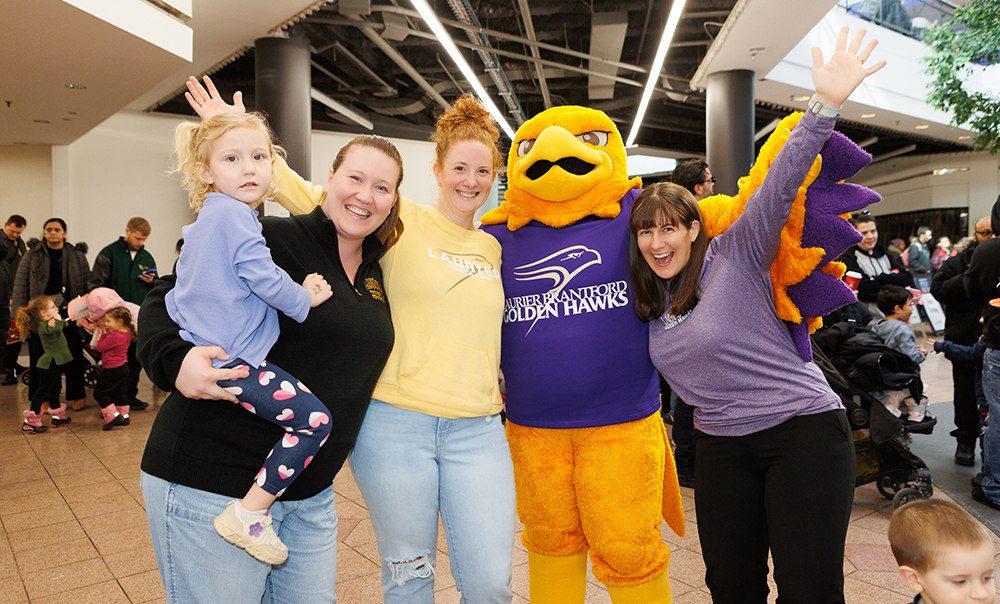 Guests mingle with Laurier's mascot, Midas, at the Purple and Gold Party