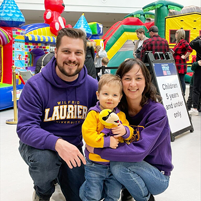 A mother, father and a young child in front of a bouncy castle