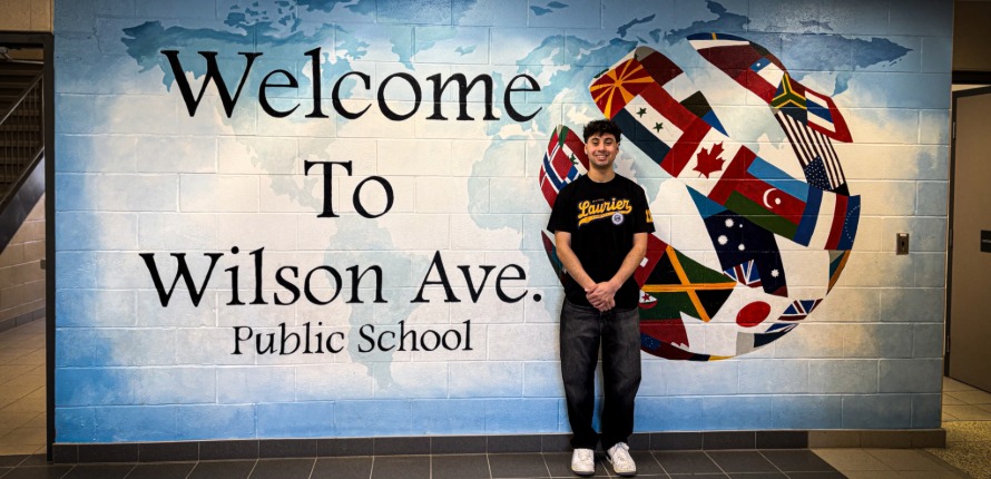 Almeida poses in front of the Wilson Ave mural